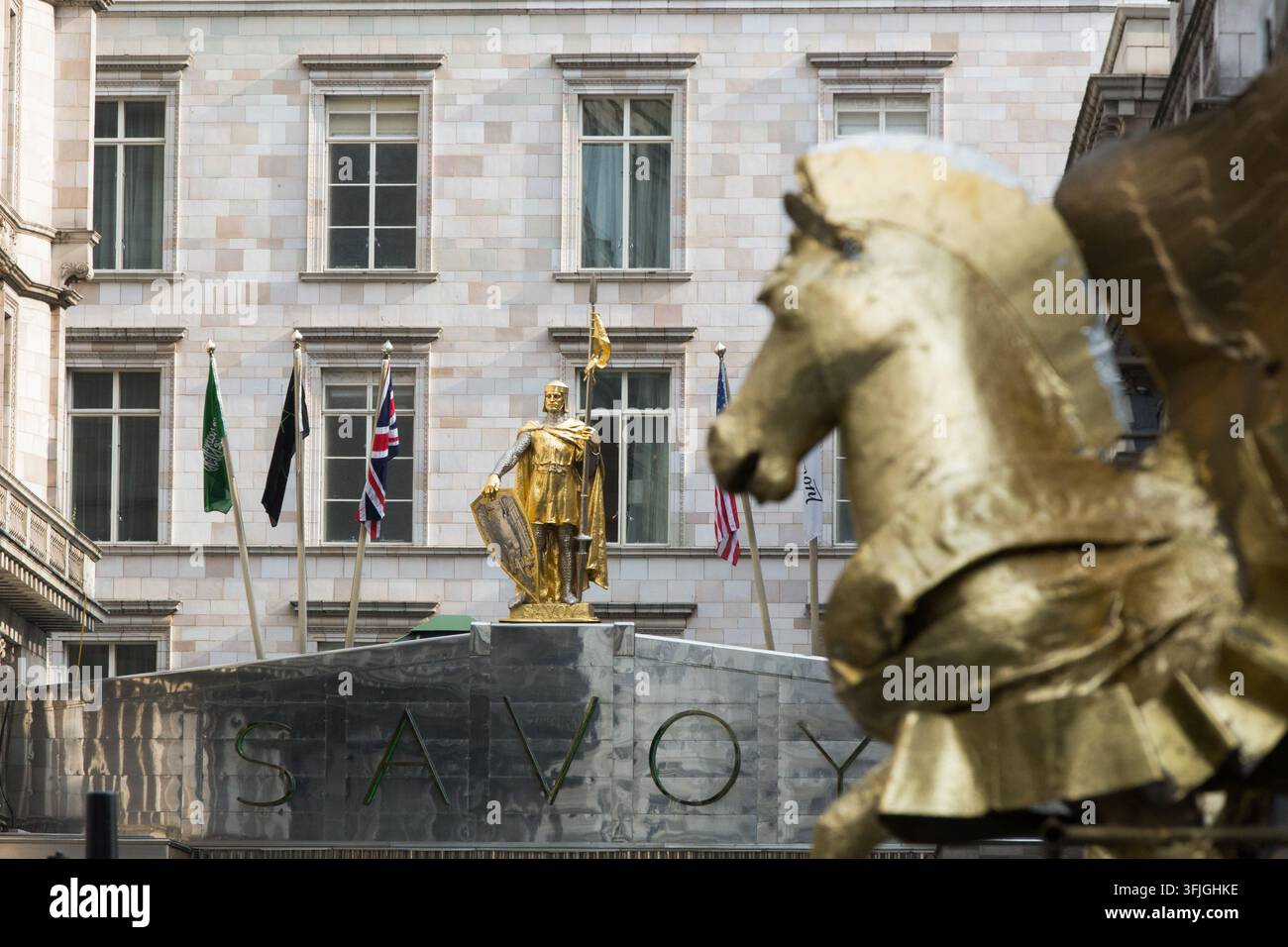 La statue dorée du comte Pierre de Savoie et les drapeaux ornent l'entrée de l'emblématique hôtel Savoy de Londres pour accueillir les visiteurs. Banque D'Images