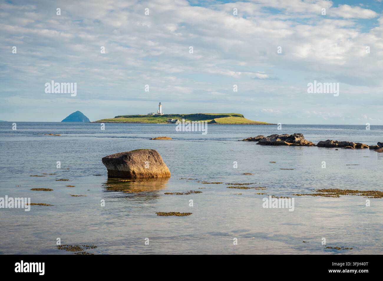 Image à plusieurs niveaux avec un gros rocher, puis le phare de Pladda et au loin l'île conique d'Alisa Craig, Écosse Banque D'Images