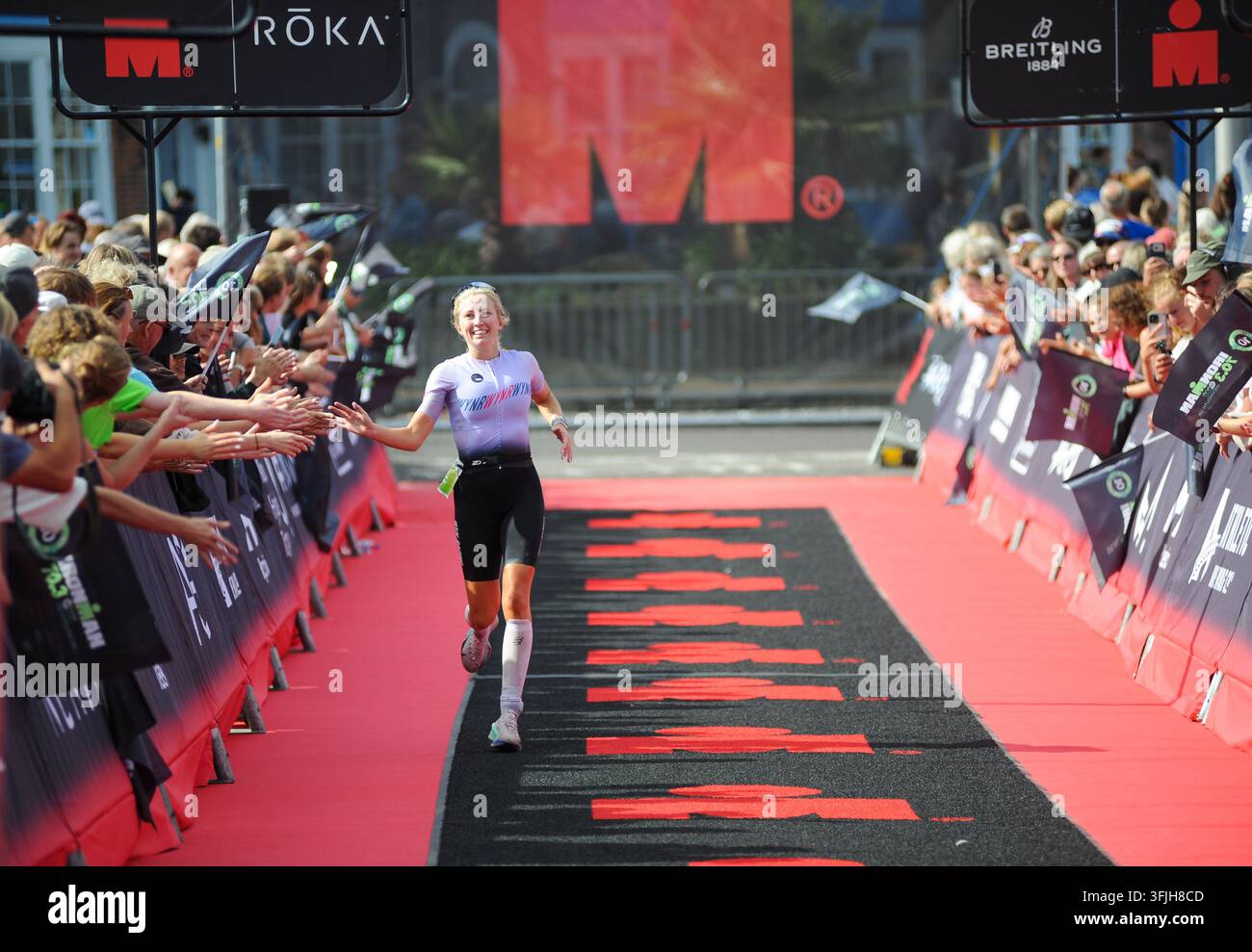 Weymouth, Dorset, Royaume-Uni. 20 sep., 2026. Katherine Amps (112) franchit la ligne d’arrivée pour remporter la course féminine de l’IRONMAN 70.3 Weymouth en un temps de 4 h 49 min 10 s. Crédit : David Partridge/Alamy Live News Banque D'Images