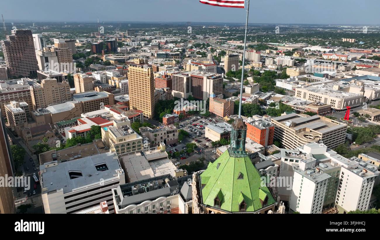 Centre-ville de San Antonio au Texas avec le drapeau américain des États-Unis flottant au vent. Montée aérienne. Banque D'Images