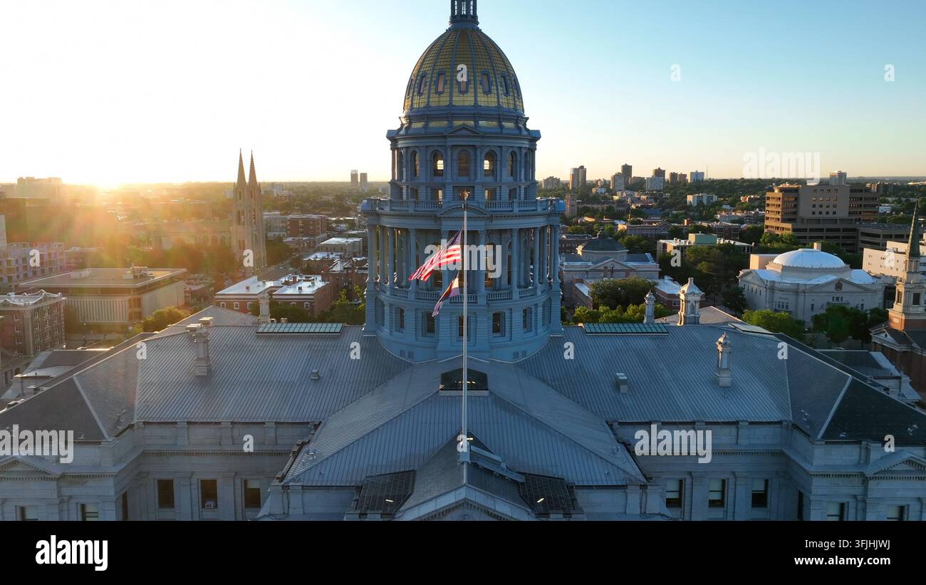 Bâtiment du capitole de l'État du Colorado. Denver est la capitale du CO. Plan aérien montant avec des drapeaux américains et du Colorado. Éclat de soleil vif, flare d'objectif duri Banque D'Images