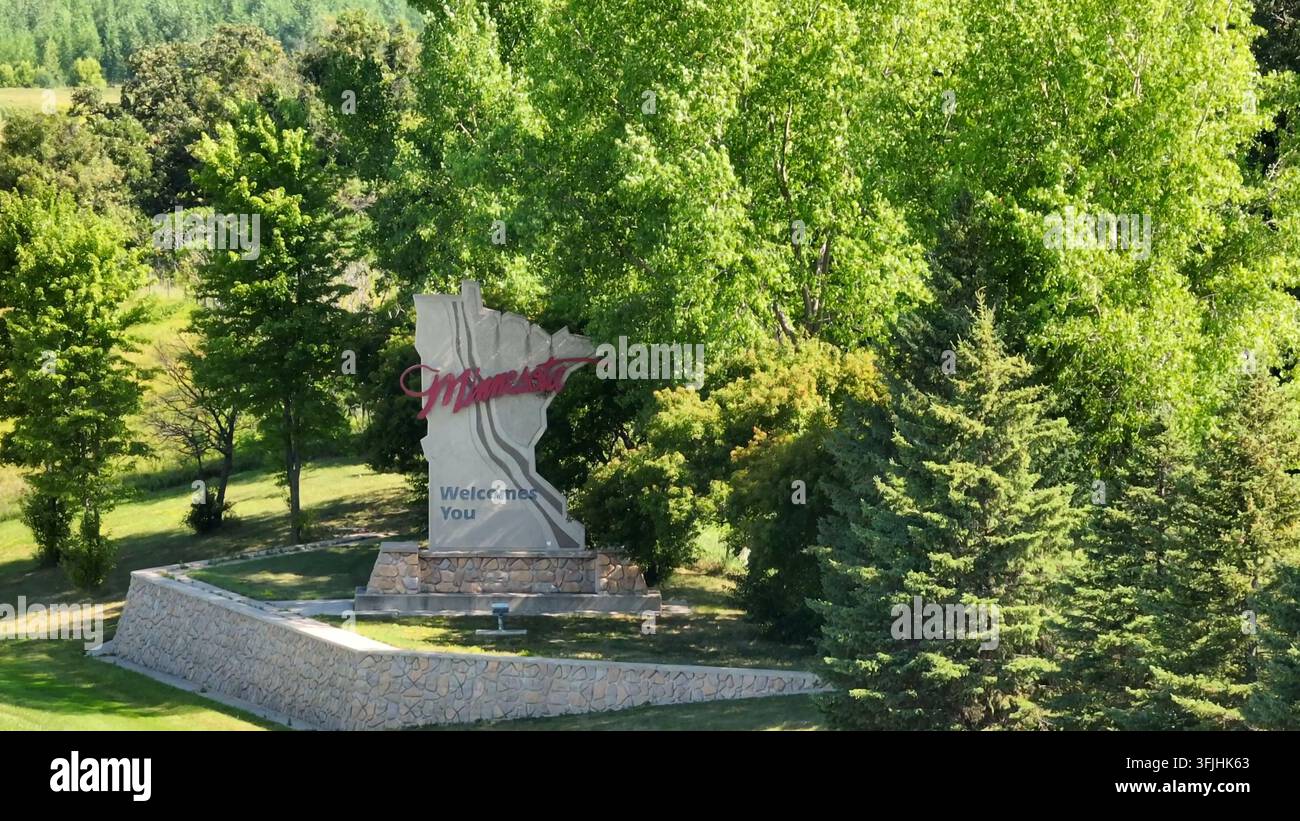 Minnesota vous souhaite la bienvenue, point de repère. Prise de vue aérienne par effet de parallaxe un jour d'été. Panneau de bienvenue en forme de MN, Freeman Township. Banque D'Images