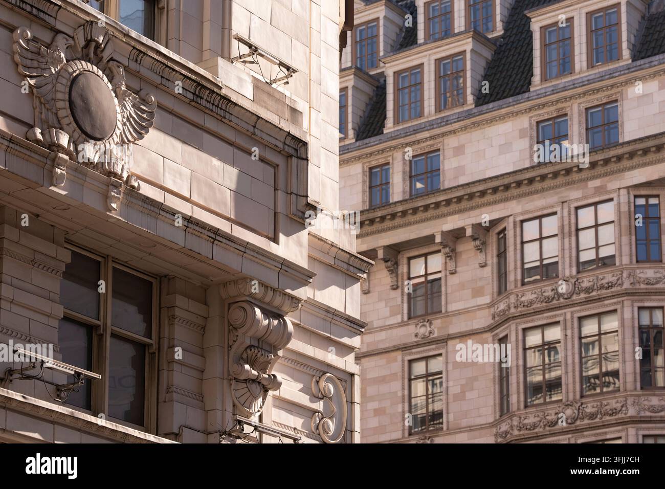 La lumière du soleil met en valeur les façades historiques ornées et l'architecture de pierre complexe des bâtiments du Strand à Londres, près de l'hôtel Savoy. Banque D'Images