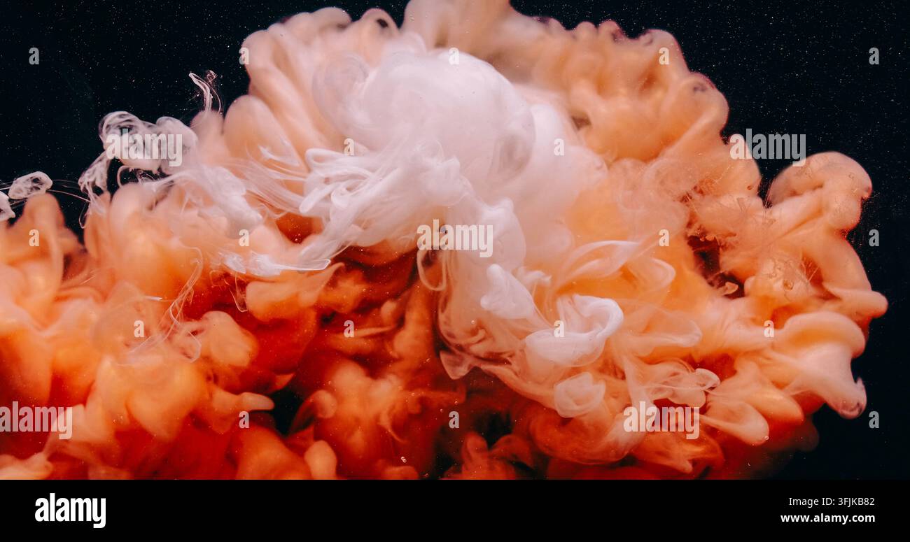 Éclaboussure de brume sous l'eau goutte d'encre nuage orange fluide Banque D'Images