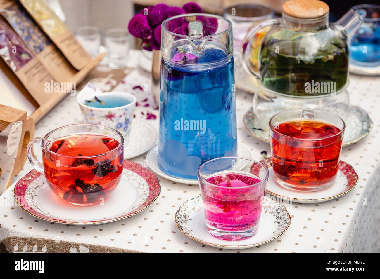 Théière en verre et tasses avec différents types de thé à base de plantes sur la table d'un marché de rue Banque D'Images