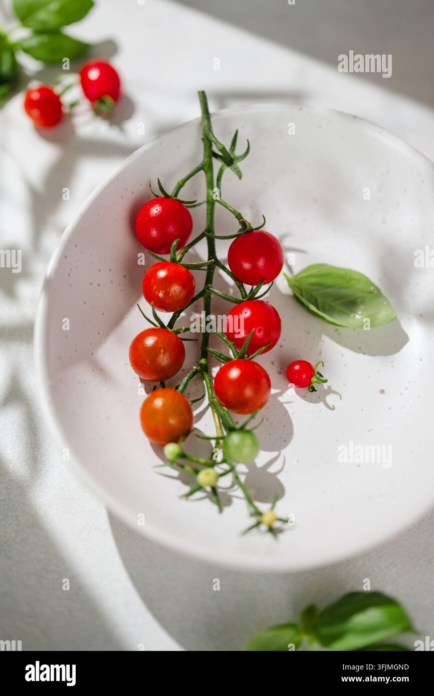 Tomates cerises mûres en poterie dans un bol en céramique Banque D'Images