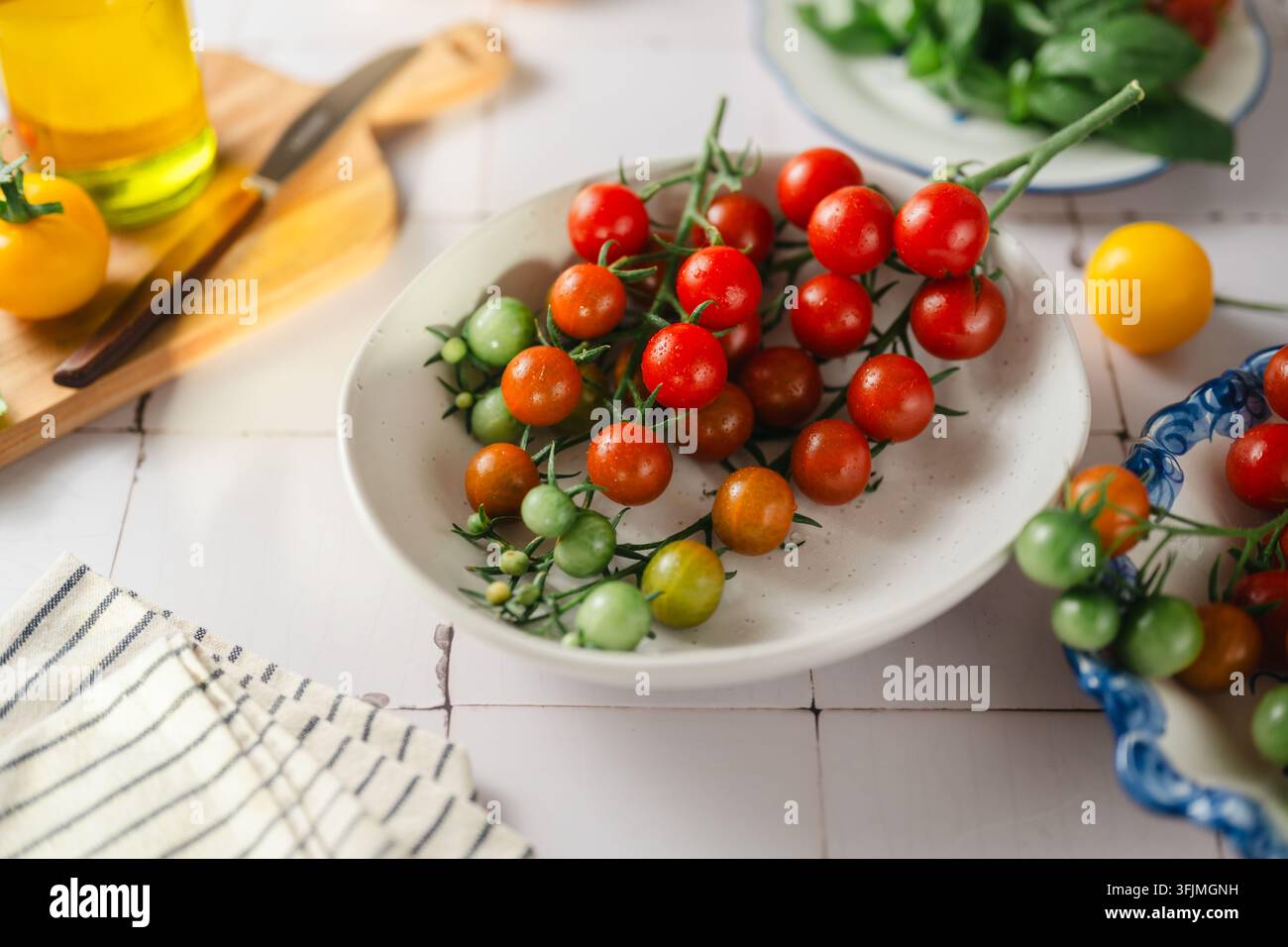 Un bol de tomates cerises fraîches et colorées sur leur vigne Banque D'Images