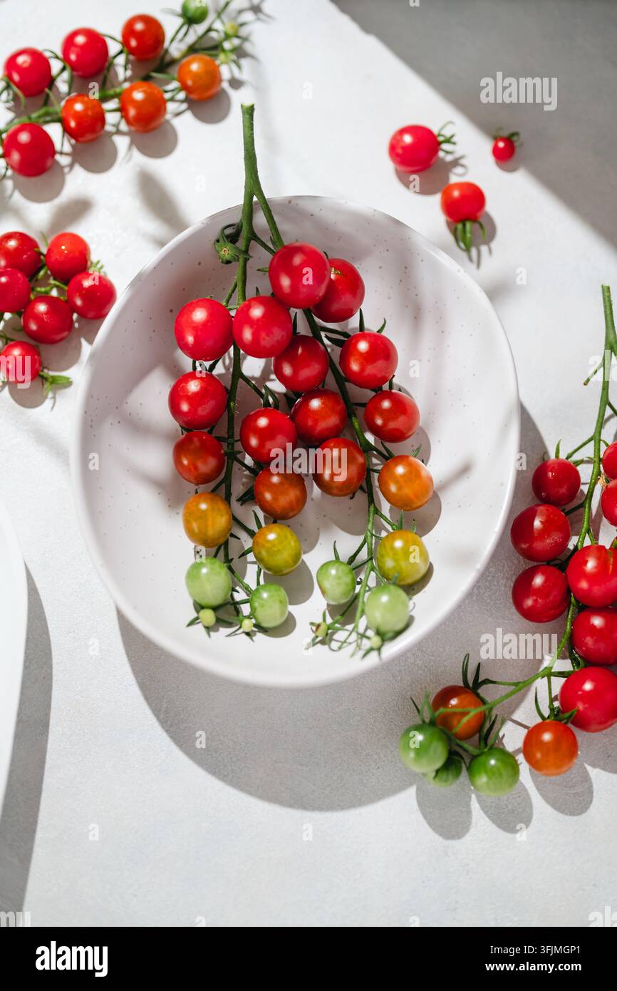 Des tomates cerises colorées mûrissant sur la vigne dans un bol Banque D'Images