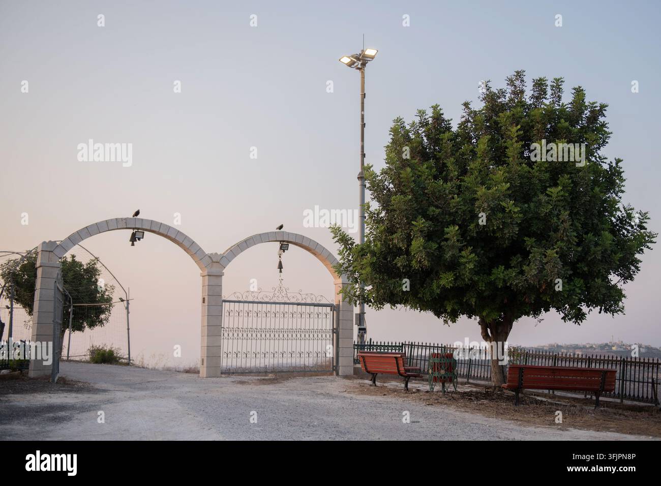 Arches de pierre et banc de parc au coucher du soleil dans un jardin pittoresque Banque D'Images