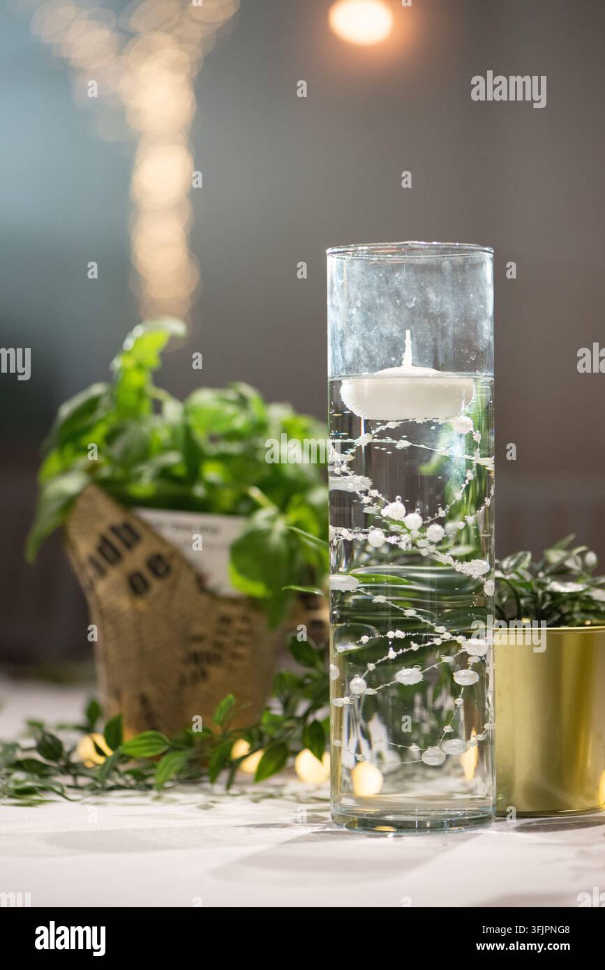 Bougie flottante dans un vase cylindrique, centre de table de mariage avec perles Banque D'Images