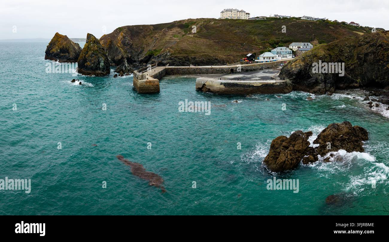 Panorama aérien du paysage du populaire village de pêcheurs de Mullion Cove sur la péninsule de Lizard dans les Cornouailles, avec une côte rocheuse et un site historique Banque D'Images