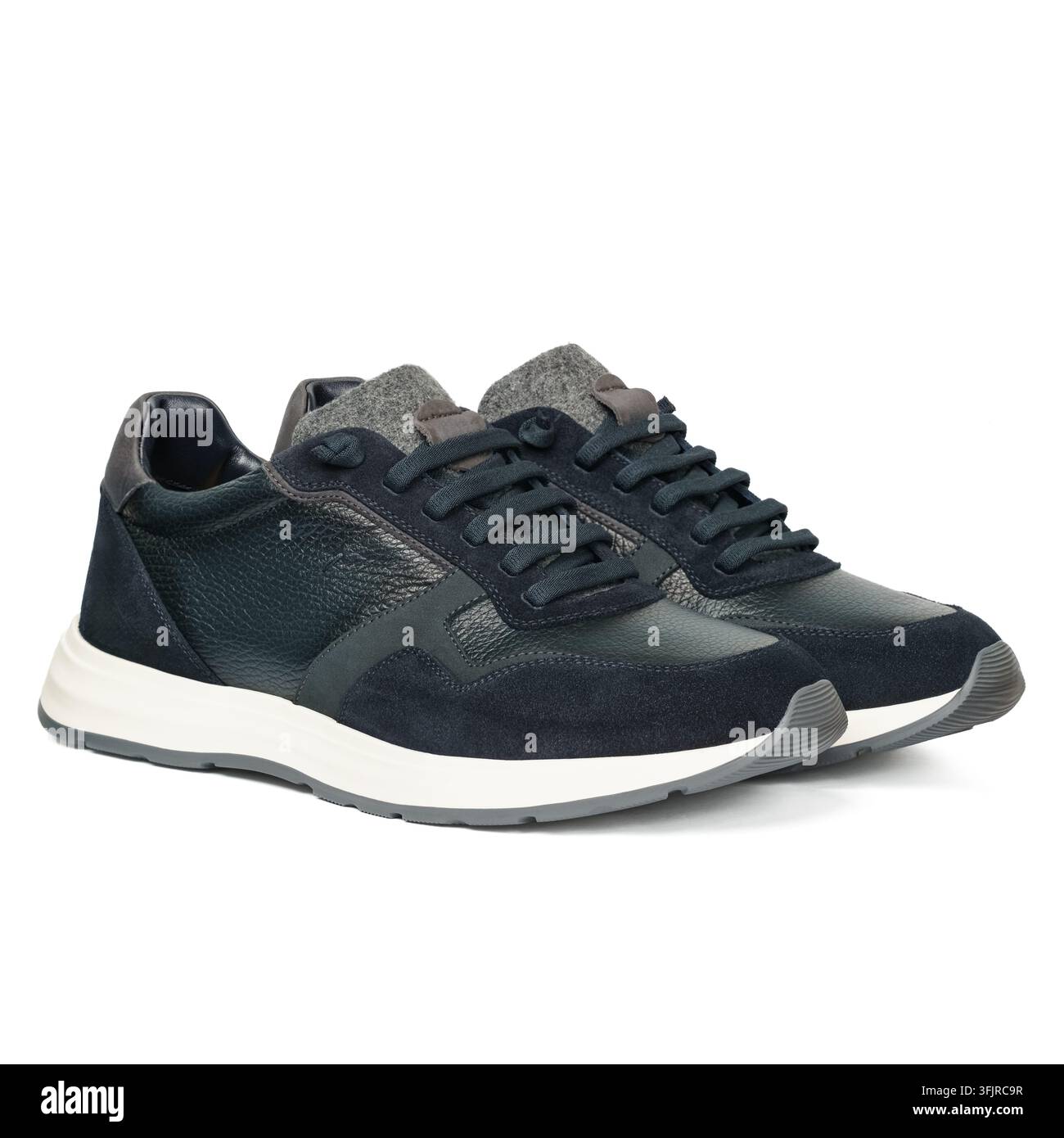Une paire de baskets noires et bleu marine à lacets avec des tiges texturées, des langues grises et des semelles intermédiaires blanches, isolées sur un fond blanc propre. Banque D'Images