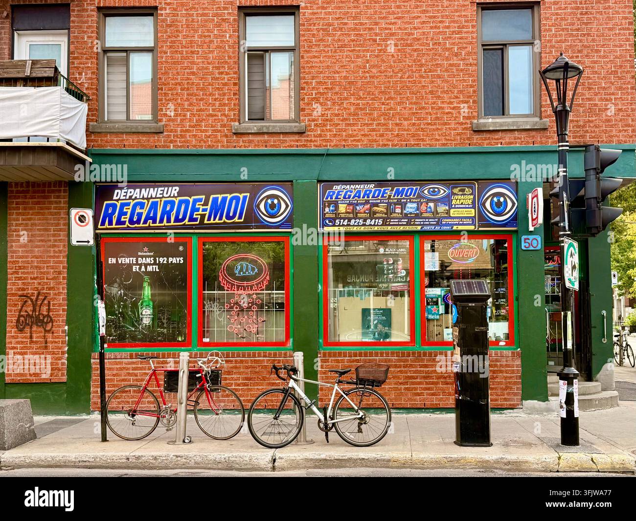 Signalisation en français sur la vitrine de Dépanneur Regarde-Moi sur la Rue Beaubien à Montréal, Québec, Canada - Image de stock capturée avec un smartphone