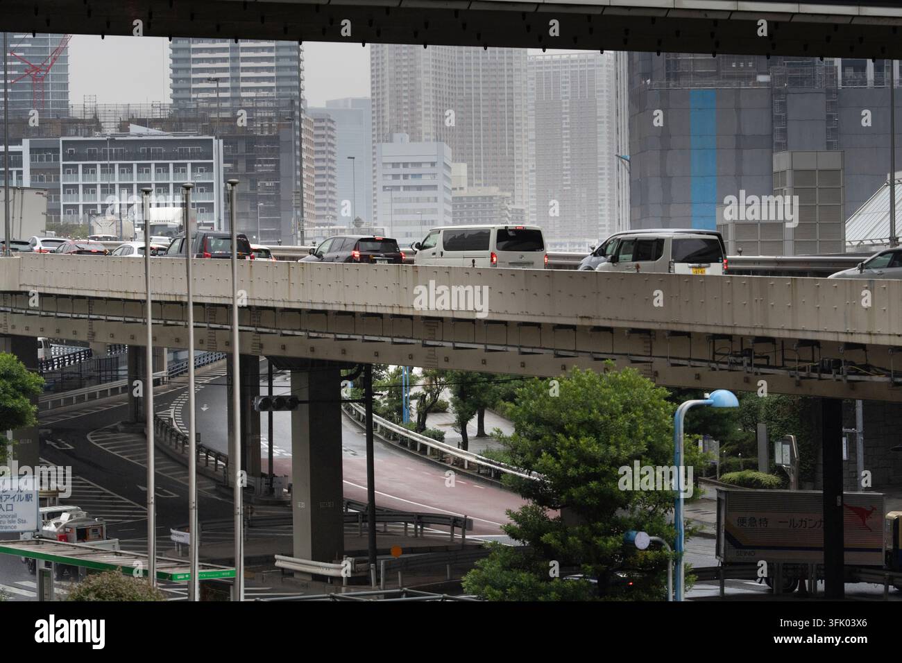 Les navetteurs roulent sur l'autoroute Shuto à plusieurs niveaux à Tokyo, naviguant dans le réseau de transit surélevé complexe de la ville. Banque D'Images