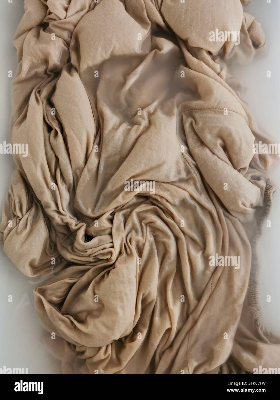 Chiffon beige doux mouillé dans un évier - Image de stock capturée avec un smartphone