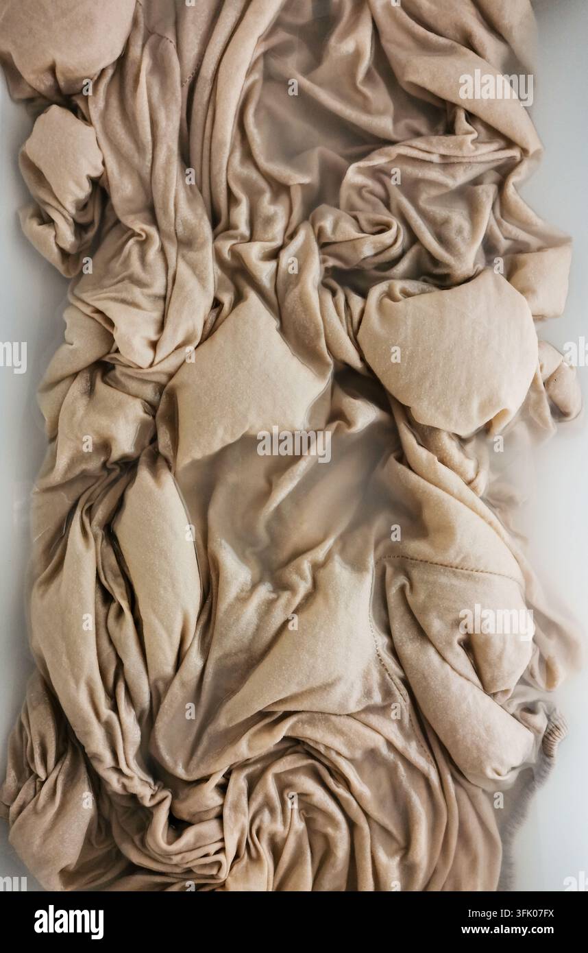 Chiffon beige doux mouillé dans un évier - Image de stock capturée avec un smartphone