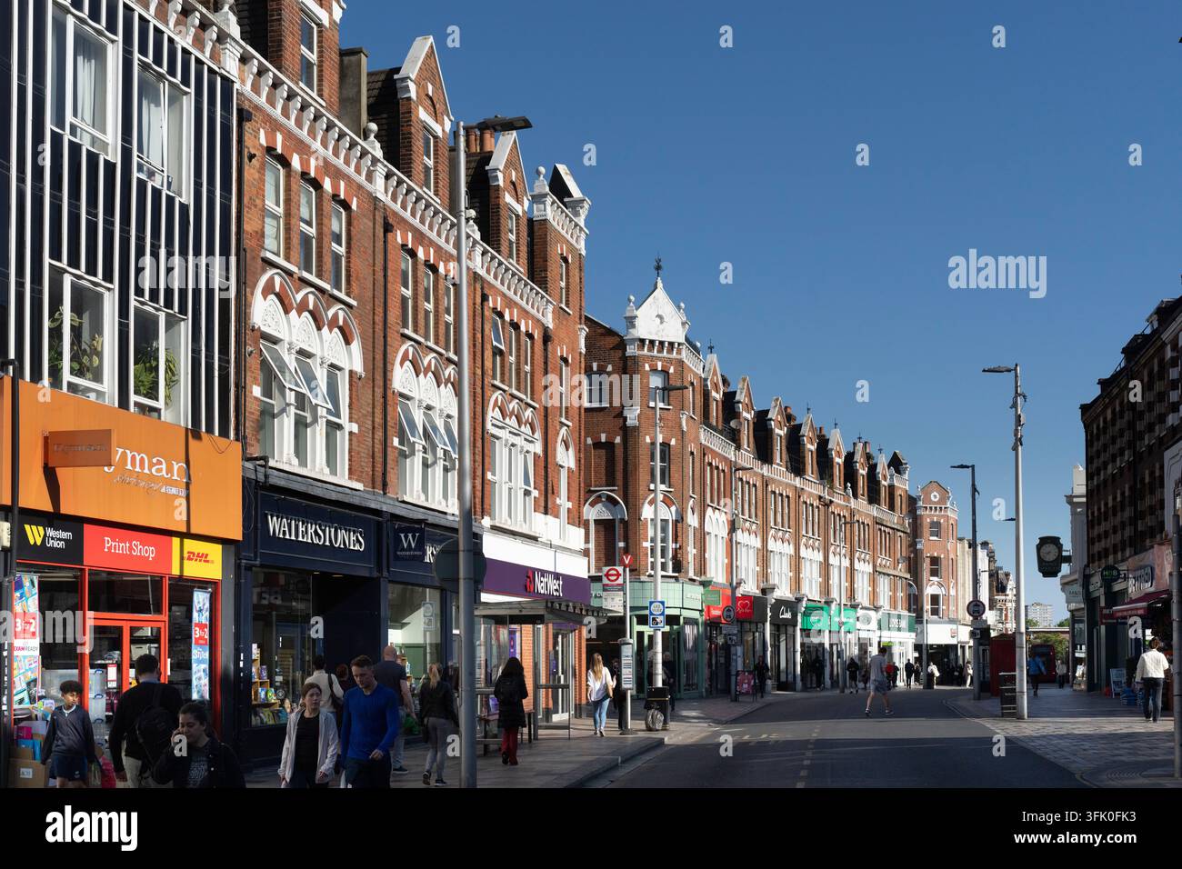Les piétons déambulent sur St. John's Hill à Clapham Junction, Londres, faisant leurs courses et leurs courses un après-midi ensoleillé. Banque D'Images