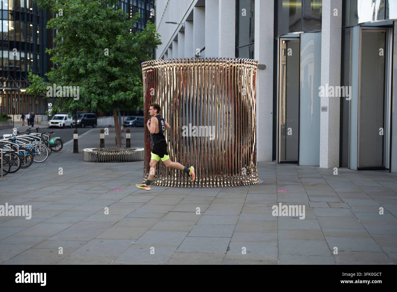Un coureur joggue devant « Whispers » d'Oscar Zieta sur Ludgate Hill, à Londres, pendant le Festival de l'Architecture de Londres. Banque D'Images