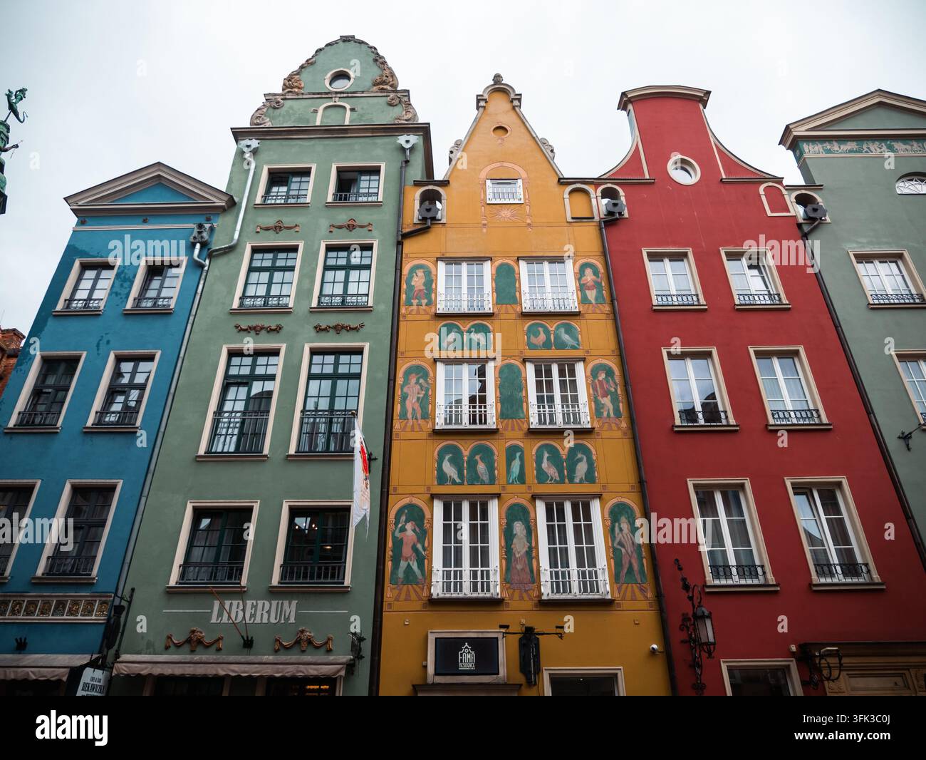 Maisons historiques colorées sur Dlugi Targ à Gdansk présentant des façades étroites ornées et des pignons décorés sous un ciel nuageux en Pologne. Banque D'Images