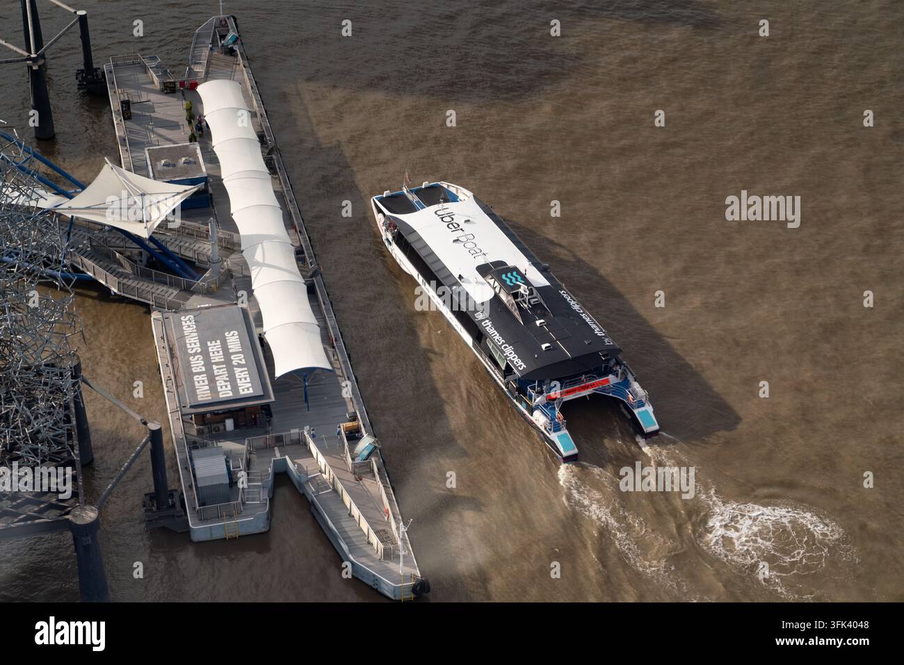 Un bateau Uber par Thames Clippers part de North Greenwich Pier sur la Tamise, assurant le transit des passagers près de l'O2 Arena. Banque D'Images