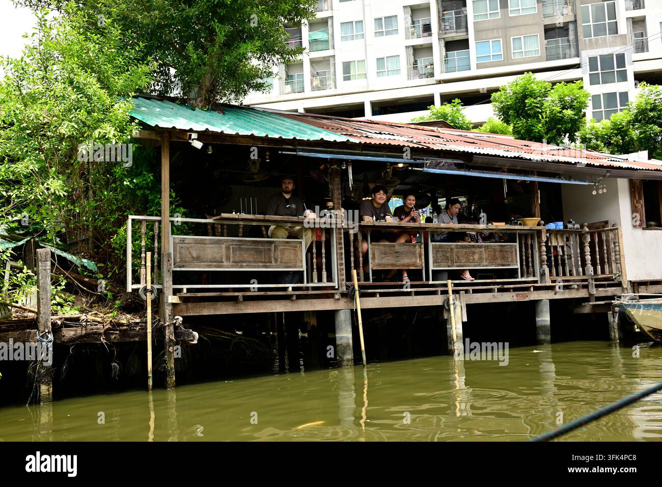 Des gens dans un restaurant sur un canal à Bangkok, Thaïlande. Banque D'Images