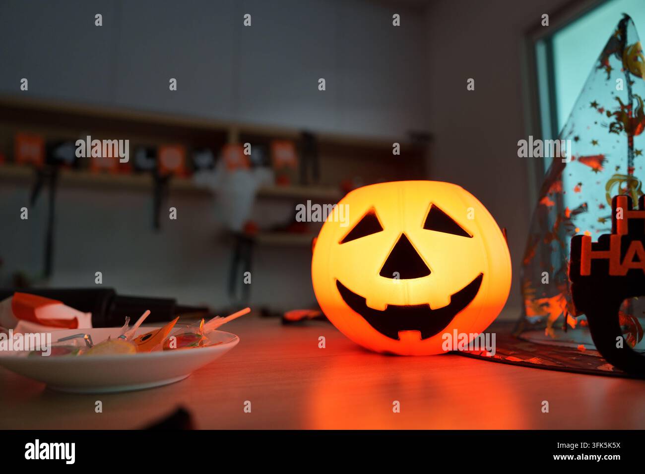 Jack-o'-lanterne d'Halloween lumineux et bonbons sur la table pour la décoration des fêtes Banque D'Images