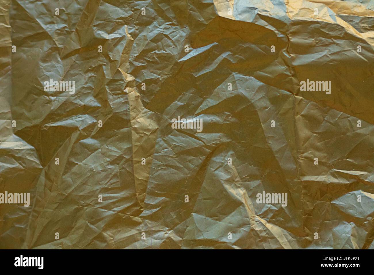 Fond texture en feuille d'or froissée avec brillance métallique et plis abstraits pour conception Banque D'Images