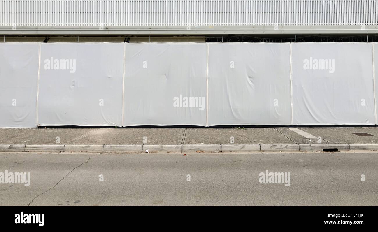 Rez-de-chaussée d'un bâtiment protégé par des bâches pour l'intimité. Trottoir en béton et rue devant. Arrière-plan pour espace de copie. Banque D'Images