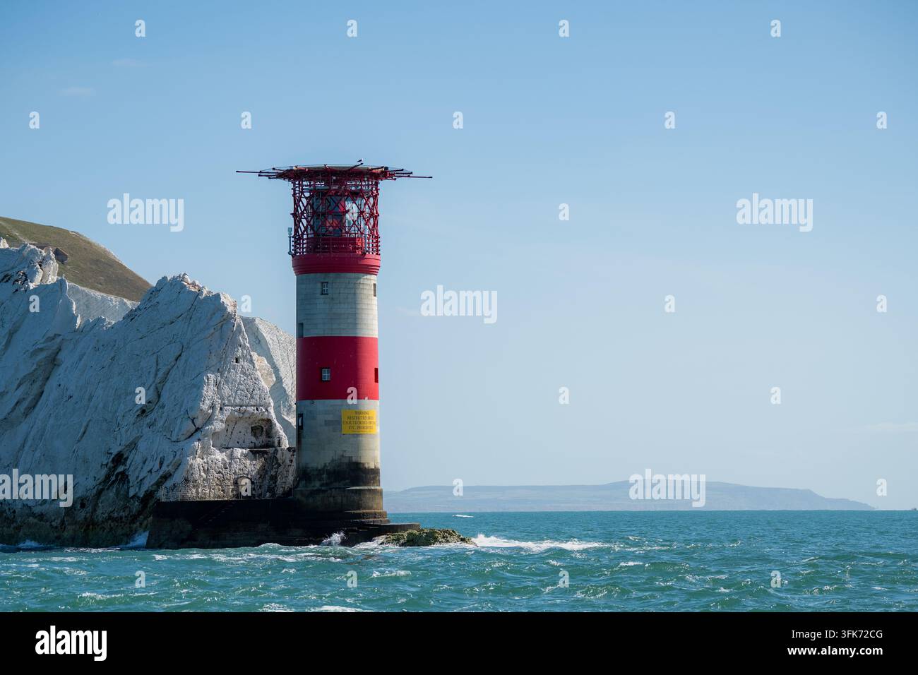 Alum Bay, Royaume-Uni - 05 septembre 2026 : Vue du phare des Needles se dressant contre des falaises de craie blanches et la mer bleue. Banque D'Images