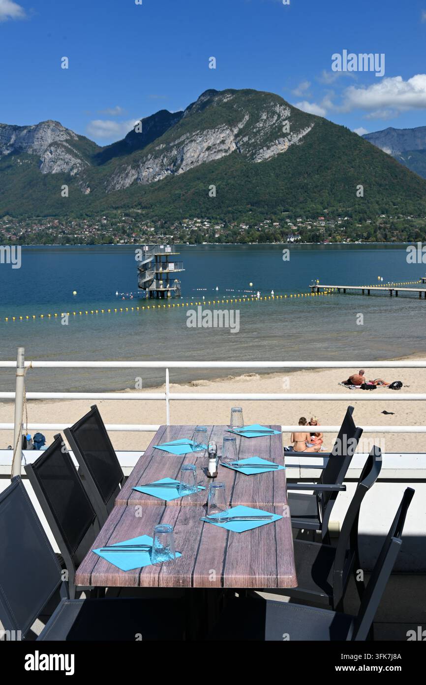 Restaurant en plein air, ou restaurant au bord du lac, avec vue sur le lac d'Annecy et les Alpes françaises avec plage à St Jorioz ou Saint Jorioz Anney France Banque D'Images