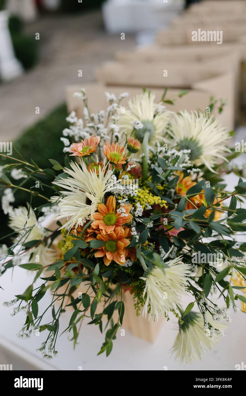 Beau bouquet de fleurs fraîches avec des chrysanthèmes blancs et des marguerites orange sur une table blanche Banque D'Images