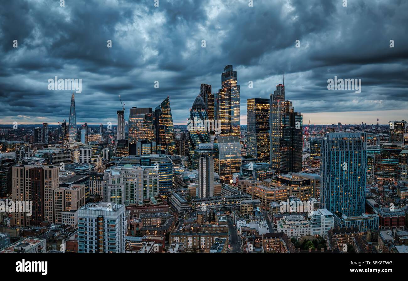 Vue aérienne atmosphérique de la ville du centre de Londres, Angleterre, au crépuscule avec un ciel nuageux et les lumières des bureaux Banque D'Images