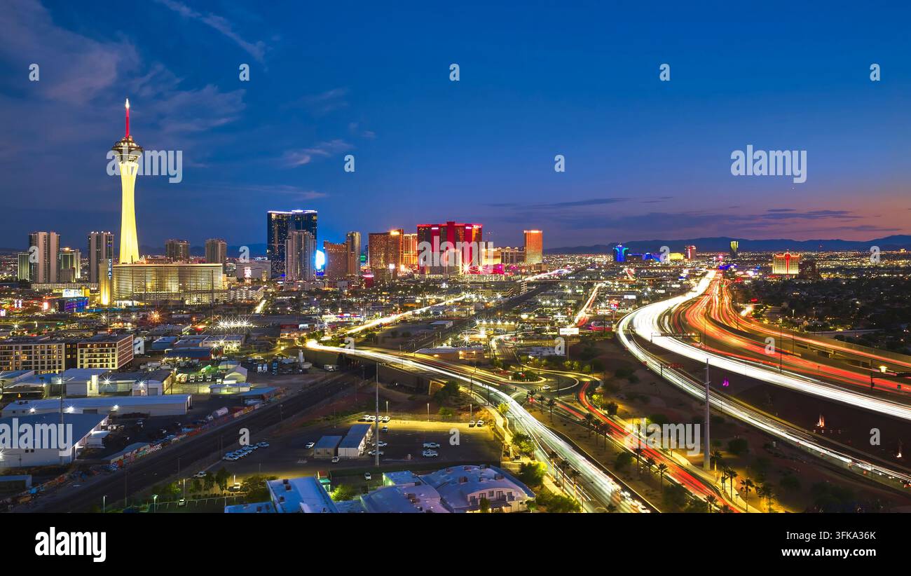 Vue aérienne du Strip de Las Vegas dans le Nevada à l'heure bleue avec la tour Stratosphere et les traînées de voitures vibrantes illuminant le paysage urbain animé en dessous Banque D'Images