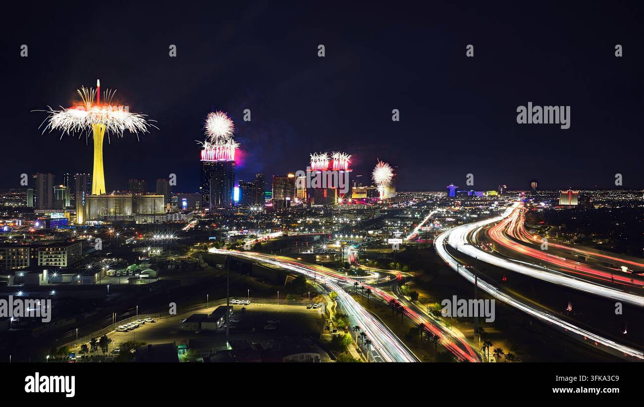 Les feux d'artifice illuminent le Strip de Las Vegas dans le Nevada le Quatre juillet alors que les traces de voitures serpentent à travers la ville sous le ciel nocturne. La vue aérienne capt Banque D'Images