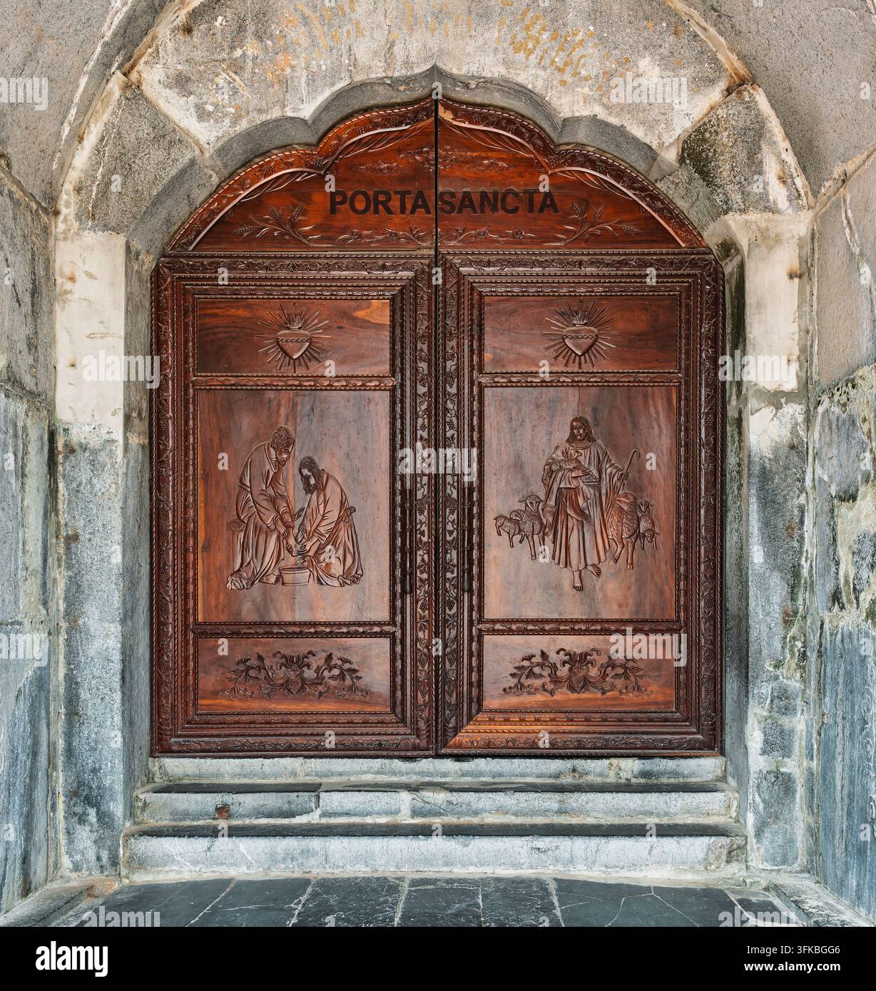Vue détaillée des portes en bois finement sculptées Porta Sancta de la cathédrale historique de Phat Diem à Ninh Binh, au Vietnam, mettant en valeur des icônes religieuses Banque D'Images