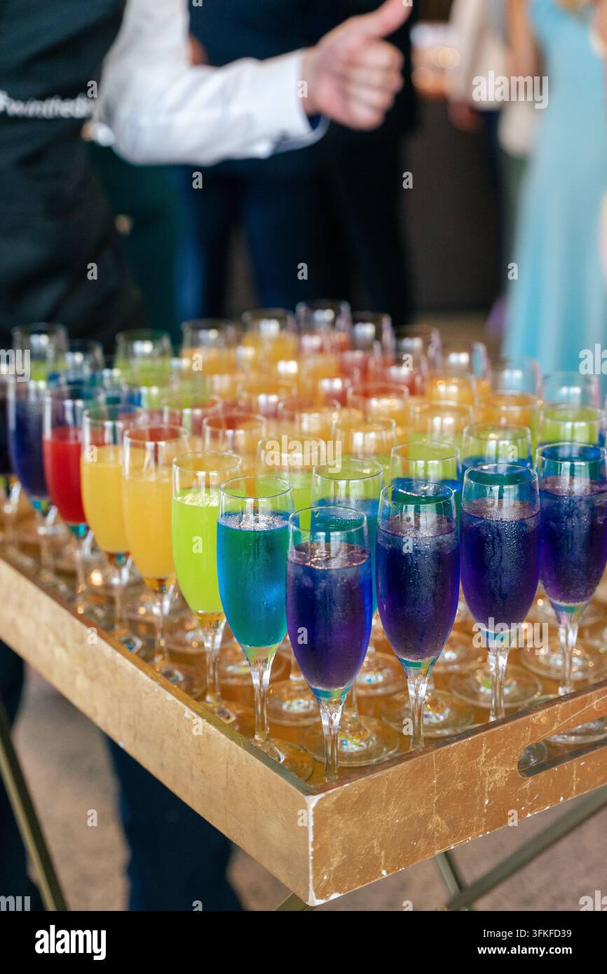 Plateau de cocktails colorés dans des flûtes à champagne lors d'un événement de fête Banque D'Images