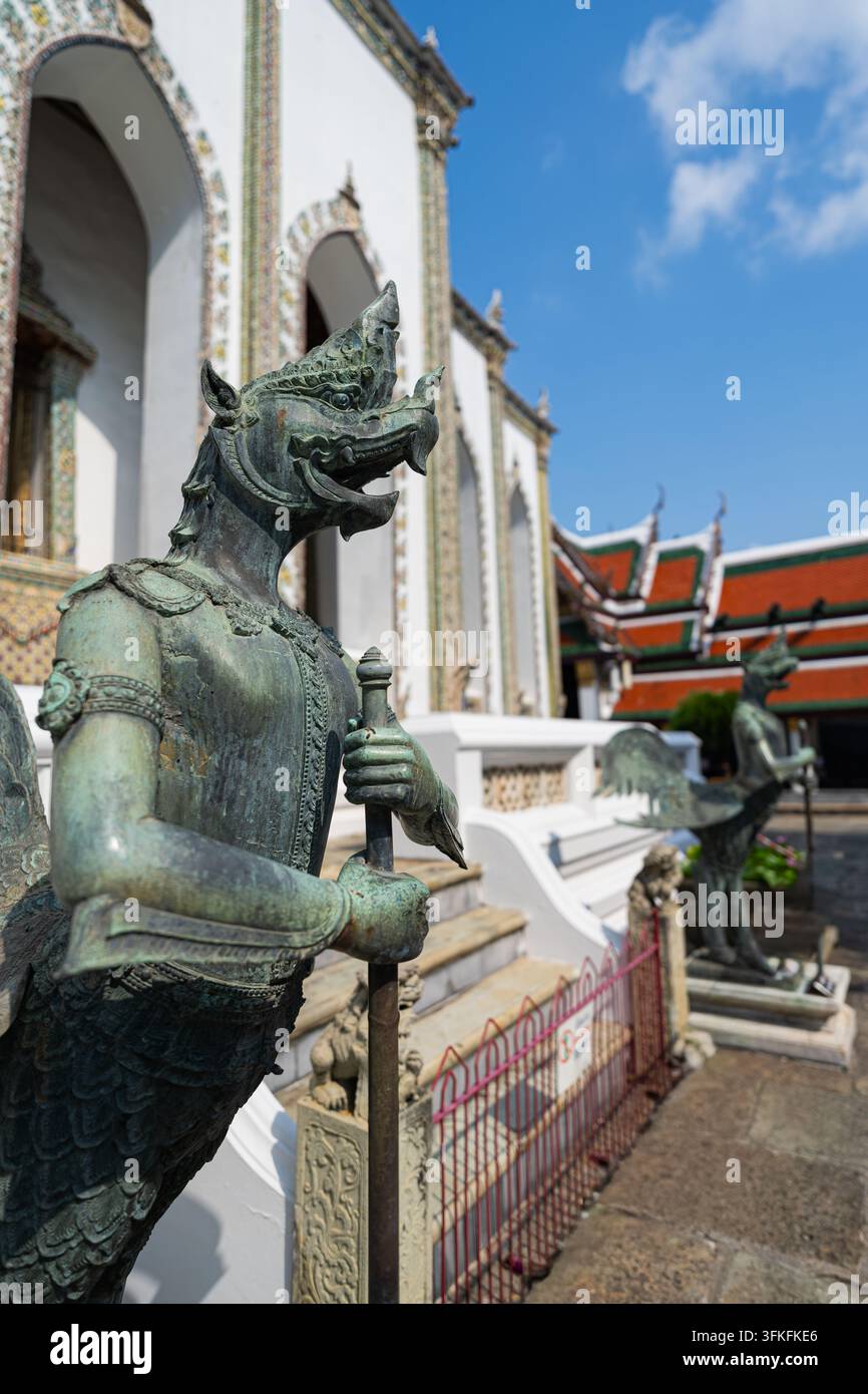 Close-up d'une statue en bronze de la créature mythique Kinnara tenant un bâton sur la terrasse supérieure du Wat Phra Kaew à Bangkok, Thaïlande Banque D'Images