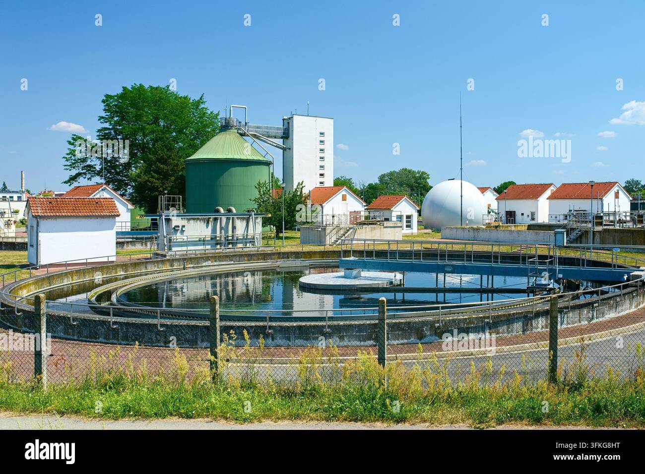 Zone de traitement des eaux usées à Breclav avec un bac de décantation circulaire, des bâtiments et des équipements technologiques sous le ciel. Banque D'Images