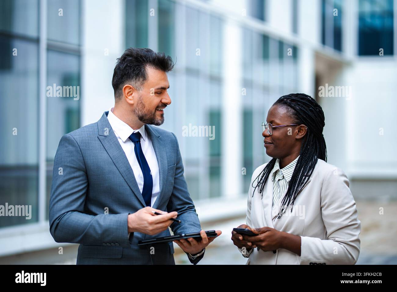 Diverses professionnels discutant du travail en utilisant une tablette en plein air Banque D'Images
