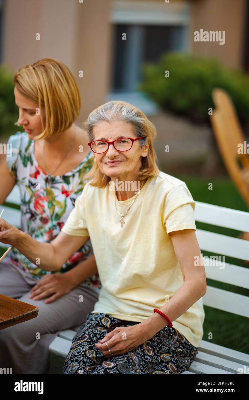 Femme âgée souriant avec sa fille adulte en plein air Banque D'Images