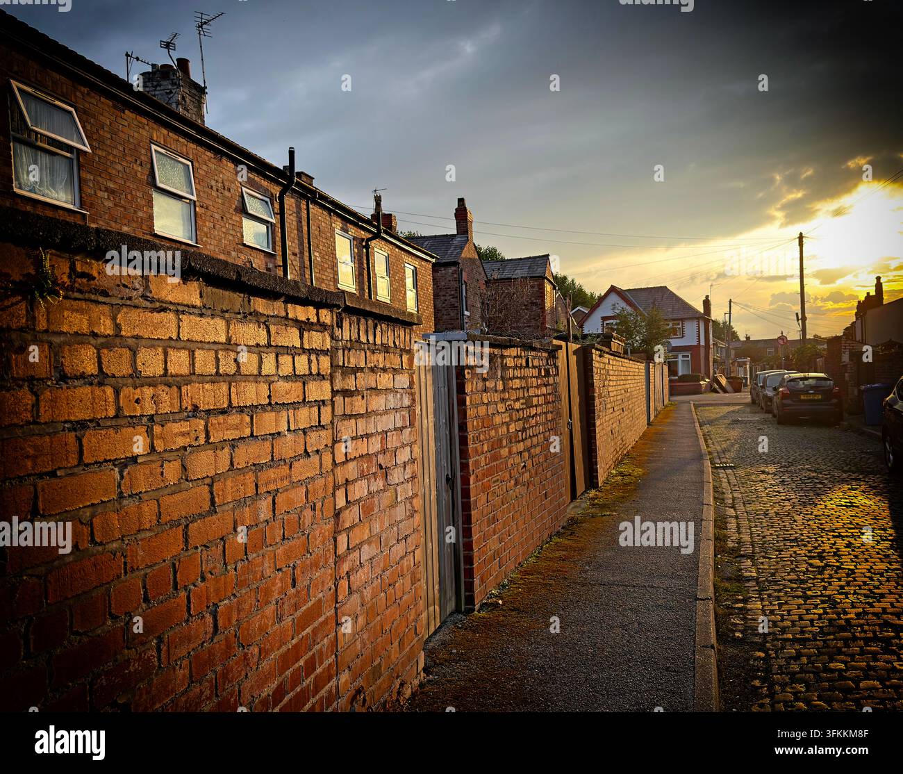 Ciel orageux sur les terrasses et les arrière-cours en briques rouges traditionnelles de Padgate, Warrington, contrastant les logements établis avec le défi des nouvelles constructions britanniques. Banque D'Images