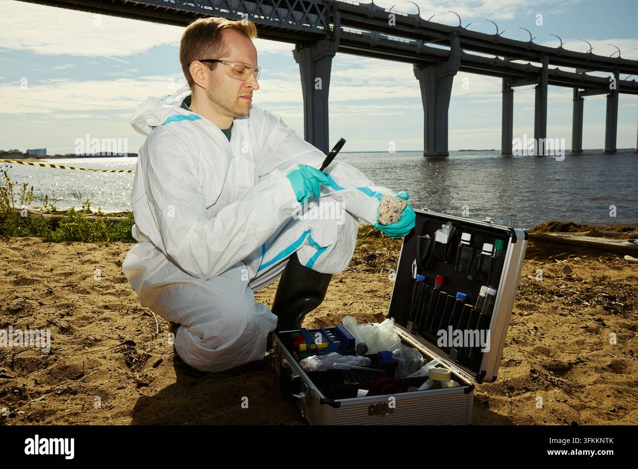 Scientifique masculin examinant un échantillon environnemental avec une loupe Banque D'Images