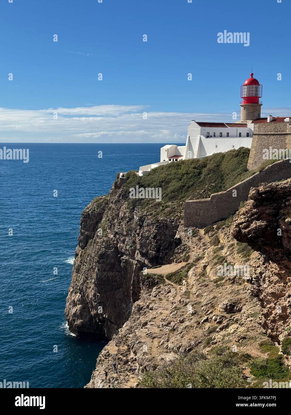 Phare sur des falaises dramatiques de l'Atlantique près de Sagres sur la côte de l'Algarve, au Portugal, surplombant l'océan Atlantique sous un ciel bleu clair. - Image de stock capturée avec un smartphone