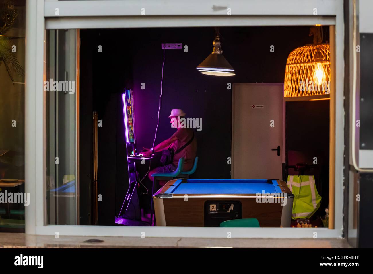 Homme jouant à une machine à sous dans un salon de jeux Banque D'Images