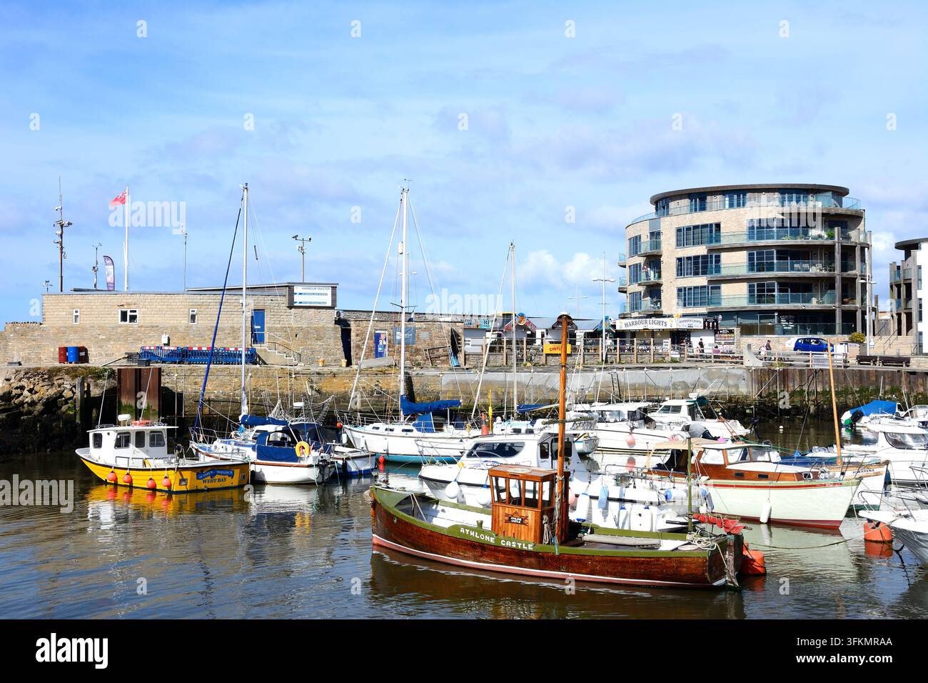 Bateaux de pêche traditionnels dans le port avec des bâtiments riverains à l'arrière-plan, West Bay, Dorset, Royaume-Uni, Europe. Banque D'Images