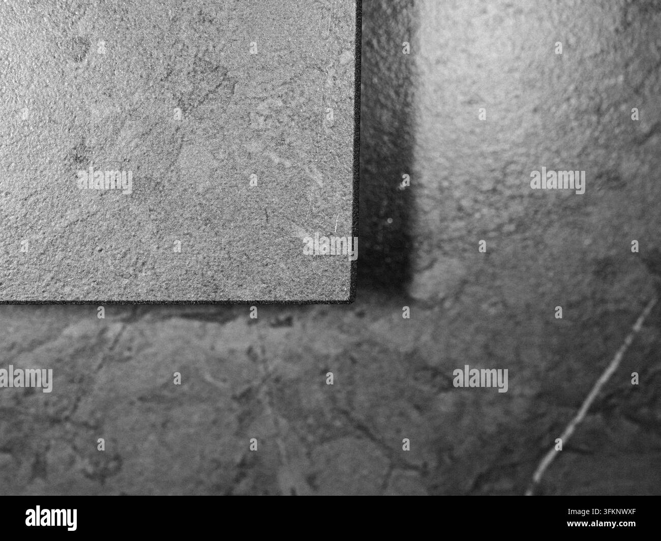 Composition géométrique monochrome de surfaces en pierre texturées avec un contraste minimaliste. Banque D'Images