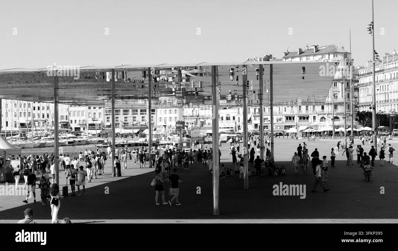 MARSEILLE, FRANCE - 16 SEPTEMBRE 2026 - Des gens profitant d'une journée ensoleillée sous la canopée réfléchissante de l'Ombrière à Marseille, France Banque D'Images