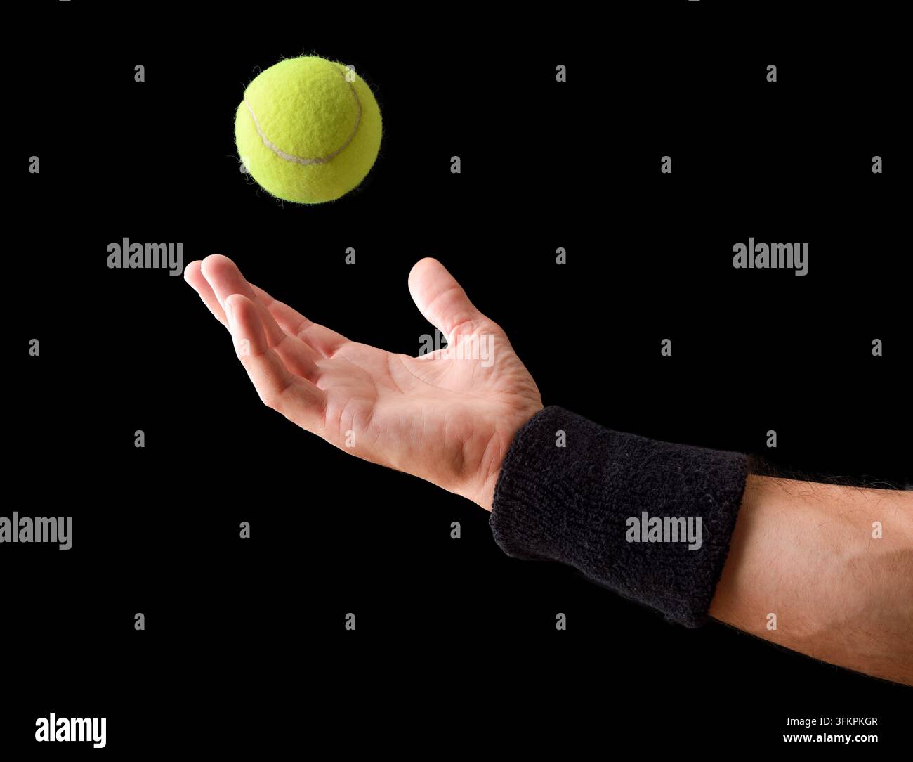 La main d'un joueur de tennis lance une balle de tennis vers le haut pendant le mouvement de service, mettant l'accent sur la préparation, la coordination, le timing et la technique athlétique agai Banque D'Images