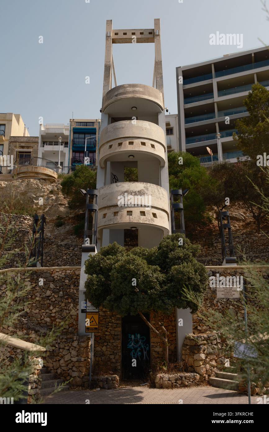 Un escalier moderne en béton à 3 étages reliant la rue du bord de mer inférieure aux rues supérieures à Bugibba, Malte. Banque D'Images