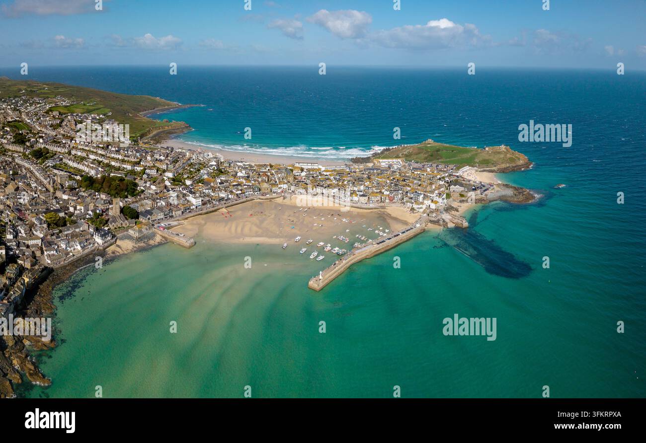 Un paysage panoramique aérien de la ville touristique populaire de St Ives en Cornouailles, Royaume-Uni, avec le sable blanc de la baie du port de St Ives et un ciel bleu par une bell Banque D'Images